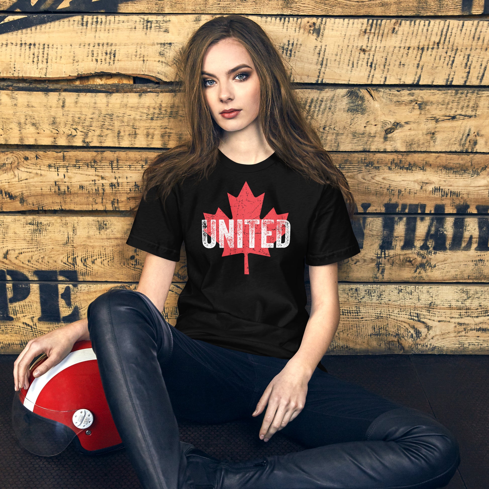 Model wearing black UNITED t-shirt with red maple leaf in casual setting